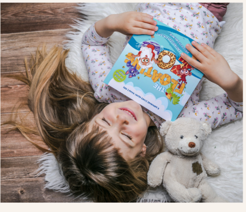 A girl relaxing with The Floating Zoo and her teddy bear